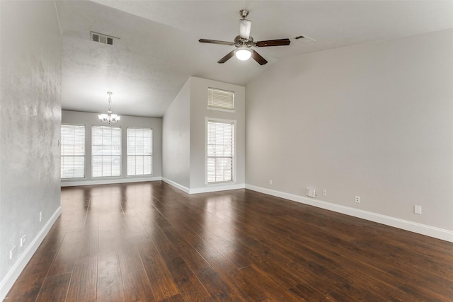 spare room with vaulted ceiling, dark wood-type flooring, and ceiling fan with notable chandelier