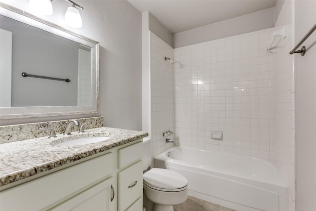 full bathroom featuring vanity, tiled shower / bath, and toilet