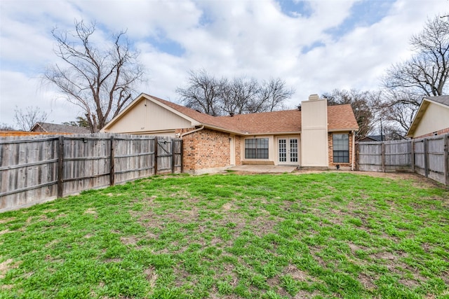 back of house featuring french doors, a yard, and a patio area