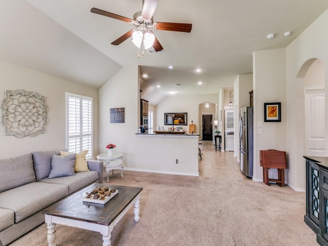 living room with ceiling fan, light colored carpet, and vaulted ceiling