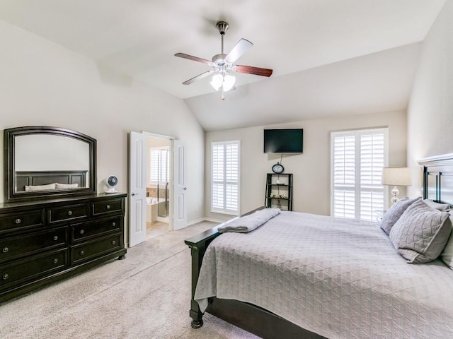 bedroom featuring lofted ceiling, ensuite bath, light carpet, and ceiling fan