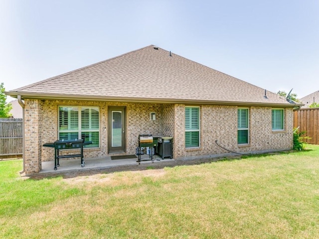 back of house with a yard and a patio