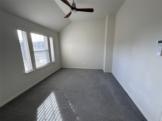 unfurnished room with dark carpet, vaulted ceiling, and ceiling fan