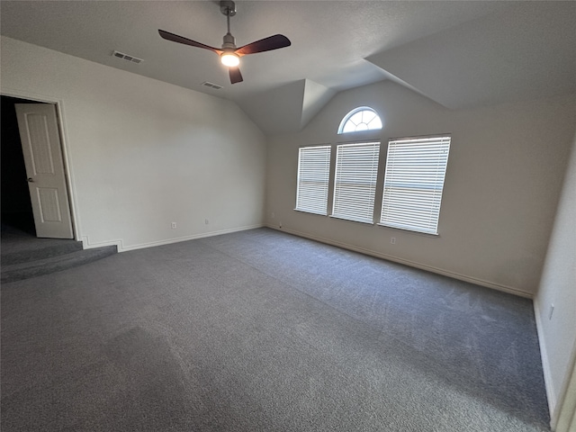 carpeted spare room featuring vaulted ceiling and ceiling fan