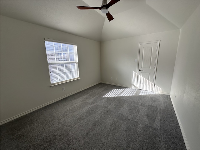 carpeted spare room featuring ceiling fan and vaulted ceiling