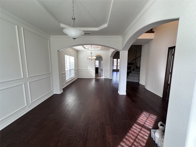 interior space featuring a tray ceiling, ornamental molding, dark hardwood / wood-style floors, and a textured ceiling