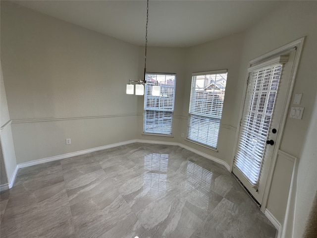 unfurnished dining area with an inviting chandelier