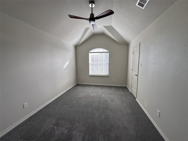 spare room featuring lofted ceiling, carpet floors, a textured ceiling, and ceiling fan