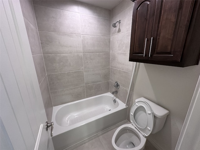 bathroom featuring tiled shower / bath combo and toilet