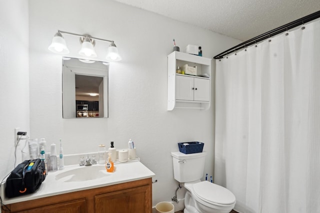 bathroom featuring vanity, a textured ceiling, and toilet