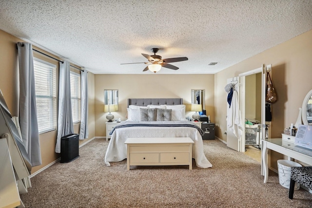 bedroom featuring light carpet, a textured ceiling, and ceiling fan