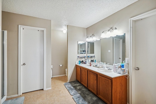 bathroom featuring tile patterned floors, toilet, vanity, and a textured ceiling