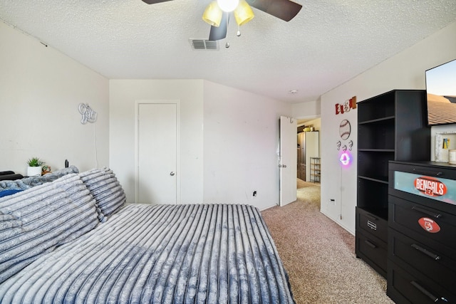 carpeted bedroom with ceiling fan and a textured ceiling