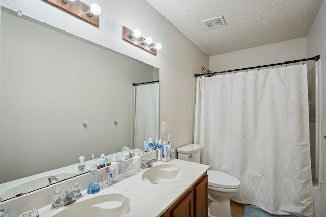 bathroom with vanity, walk in shower, a textured ceiling, and toilet