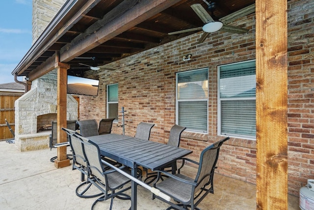 view of patio with ceiling fan and an outdoor stone fireplace