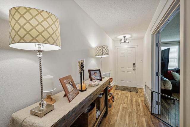 foyer entrance with hardwood / wood-style floors and a textured ceiling