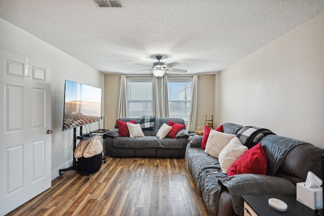 living room featuring a textured ceiling, dark hardwood / wood-style floors, and ceiling fan