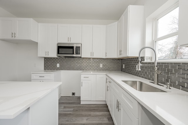 kitchen featuring backsplash, light hardwood / wood-style floors, sink, and white cabinets