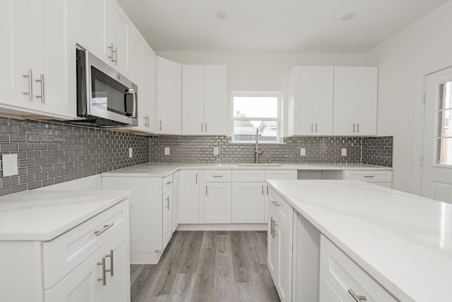 kitchen with white cabinetry, sink, decorative backsplash, and a wealth of natural light