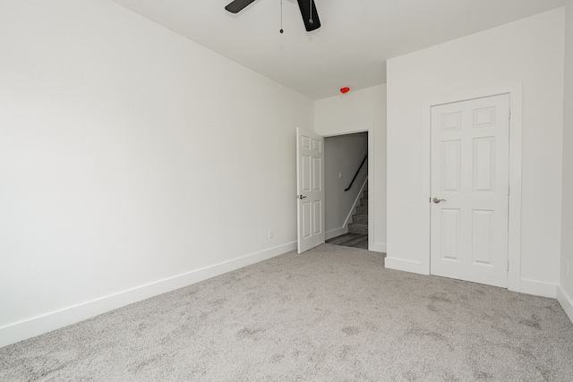 carpeted spare room featuring ceiling fan