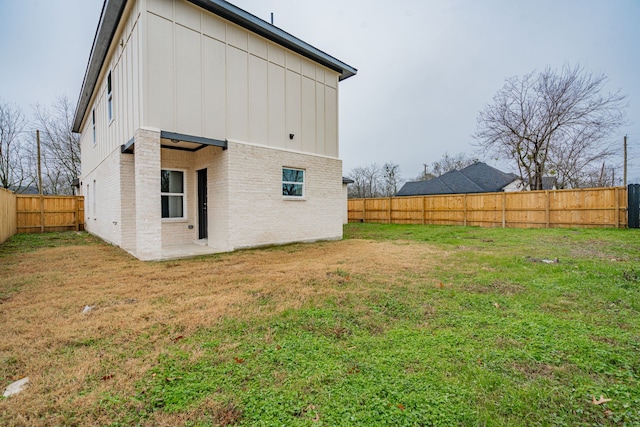 rear view of house featuring a lawn