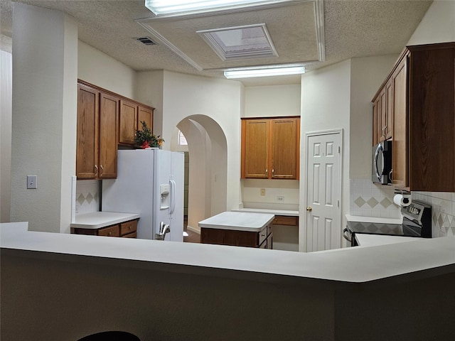 kitchen featuring a center island, backsplash, kitchen peninsula, and appliances with stainless steel finishes