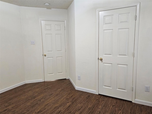 interior space with dark wood-type flooring and a textured ceiling