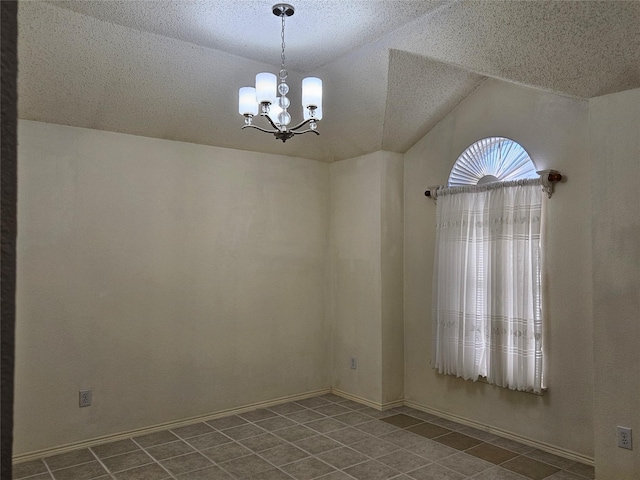 tiled empty room featuring a chandelier, vaulted ceiling, and a textured ceiling