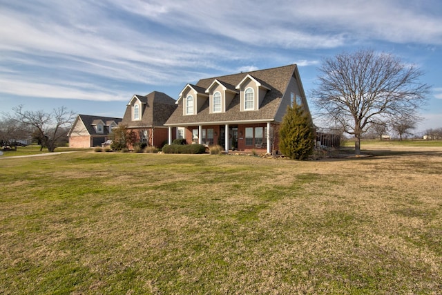 cape cod home with covered porch and a front yard