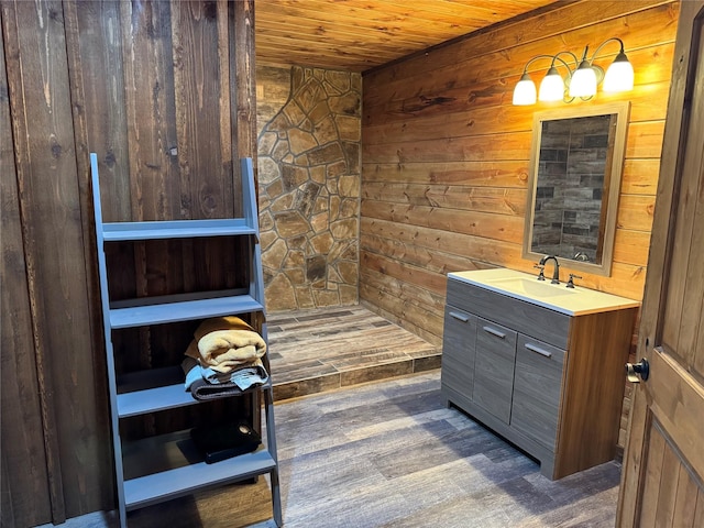 bathroom with vanity, hardwood / wood-style floors, wooden ceiling, and wood walls