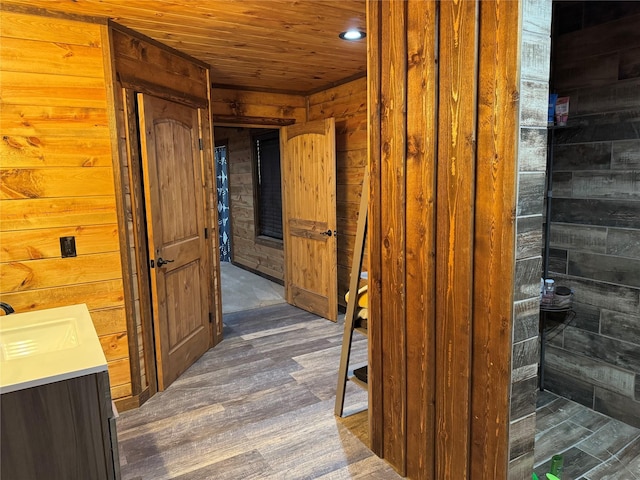 bathroom with wood ceiling, vanity, wooden walls, and wood-type flooring