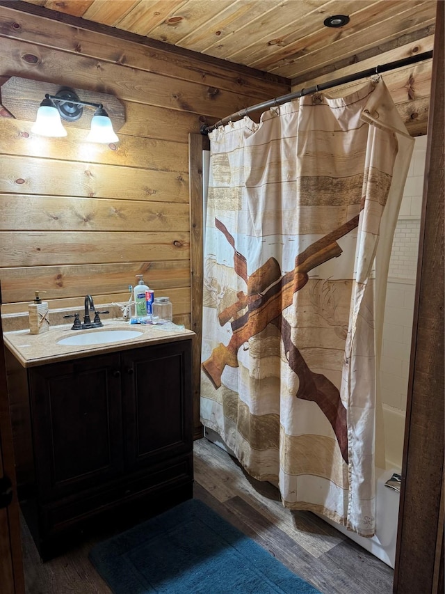 bathroom featuring sink, wooden walls, wooden ceiling, and hardwood / wood-style floors