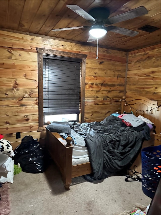 carpeted bedroom featuring wooden walls, wooden ceiling, and ceiling fan