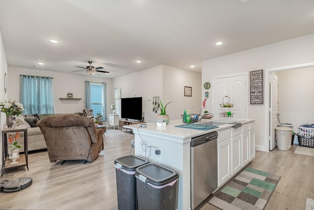 kitchen featuring sink, white cabinetry, a center island with sink, dishwasher, and light hardwood / wood-style floors