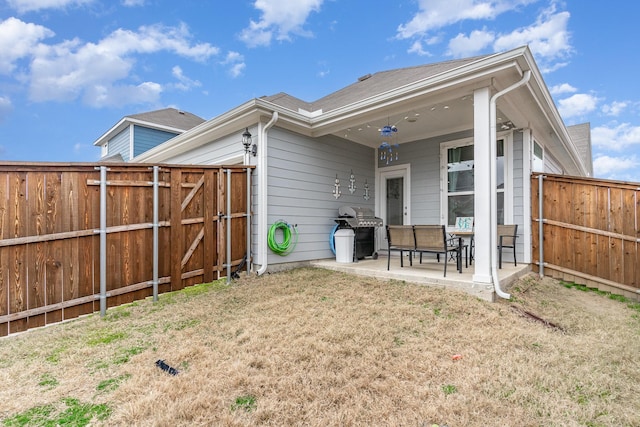 rear view of property with a yard and a patio area