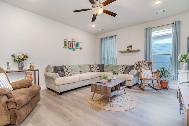 living room featuring light hardwood / wood-style flooring and ceiling fan