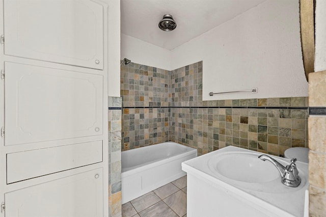 bathroom featuring tiled shower / bath, vanity, tile patterned flooring, and tile walls