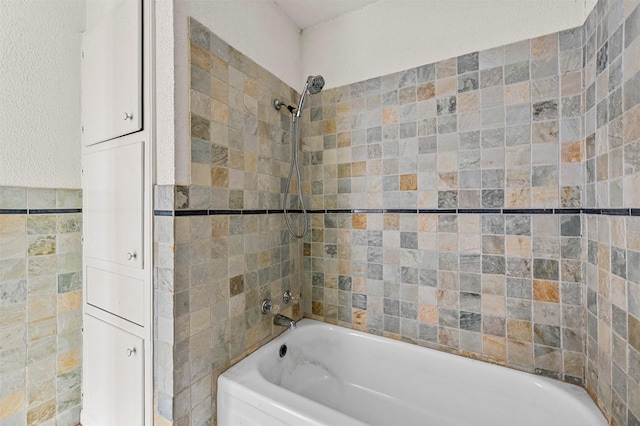 bathroom featuring tile walls and tiled shower / bath combo