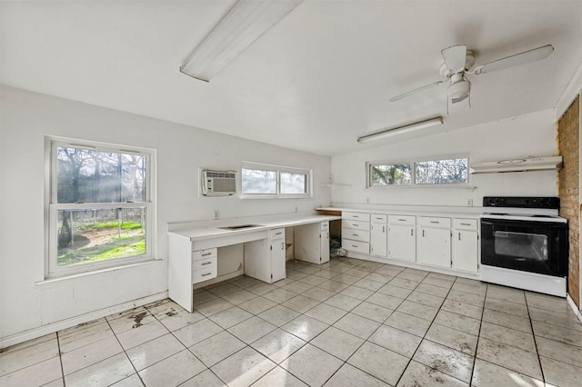 kitchen with light tile patterned flooring, white cabinetry, an AC wall unit, range with electric stovetop, and ceiling fan