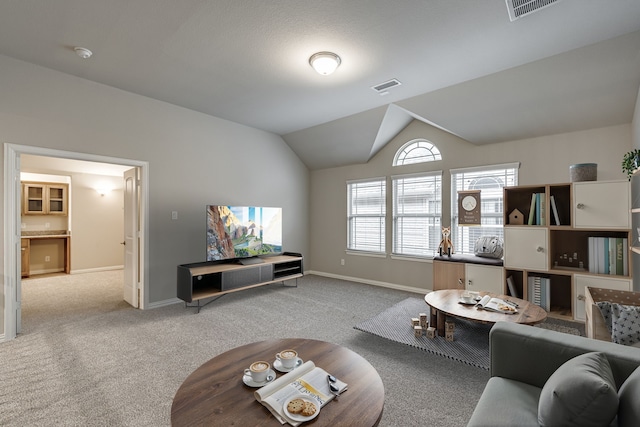 carpeted living room with vaulted ceiling