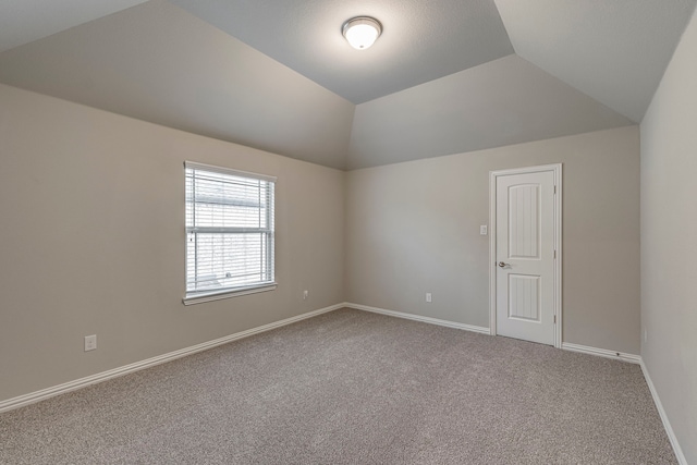 additional living space with vaulted ceiling and carpet