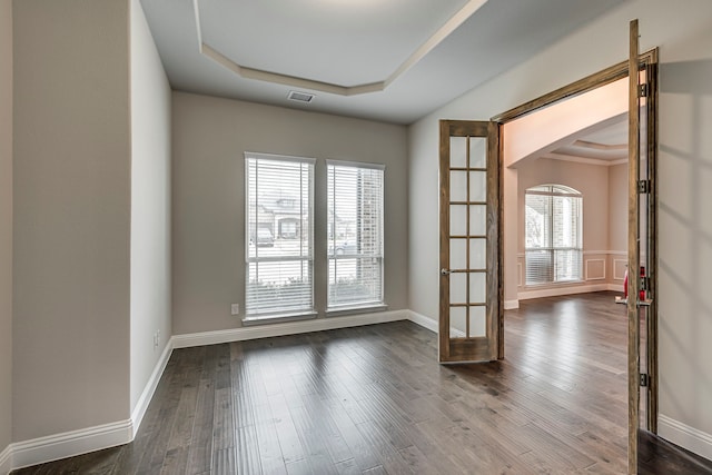 empty room with a tray ceiling and hardwood / wood-style floors