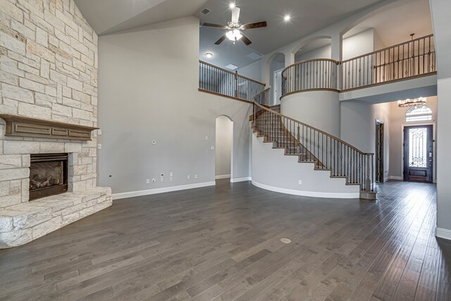 kitchen featuring hardwood / wood-style floors, a fireplace, decorative light fixtures, a center island, and light stone counters