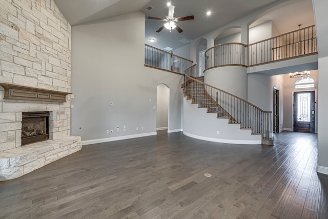 unfurnished living room with dark hardwood / wood-style floors, ceiling fan with notable chandelier, and a fireplace