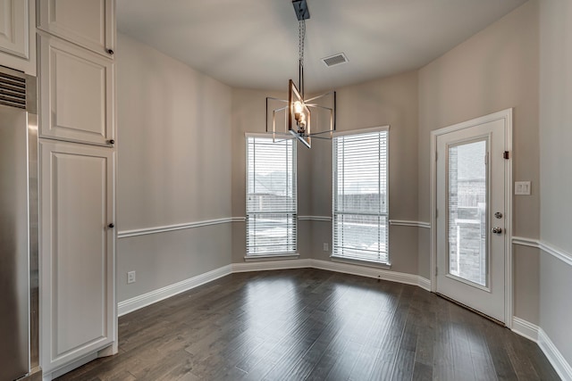 unfurnished dining area with dark hardwood / wood-style floors and a notable chandelier