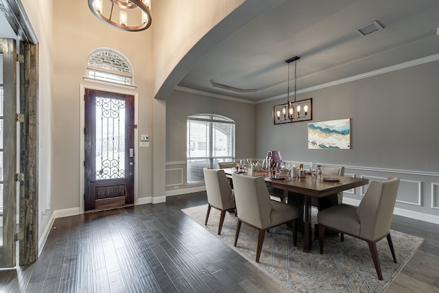 dining room with dark hardwood / wood-style flooring, ornamental molding, and a chandelier