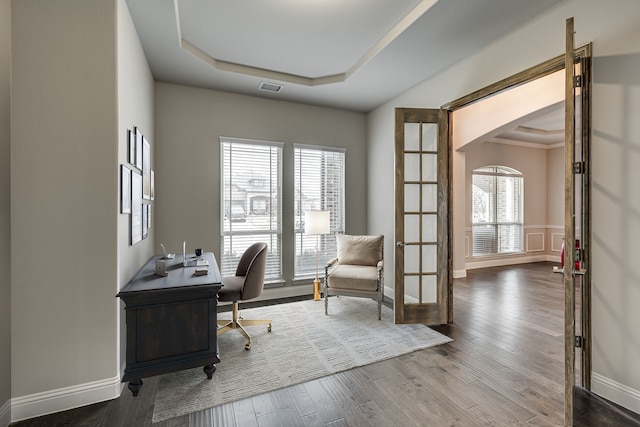 office with hardwood / wood-style flooring, a raised ceiling, and french doors