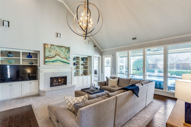 living room with hardwood / wood-style floors, high vaulted ceiling, a fireplace, ornamental molding, and a notable chandelier