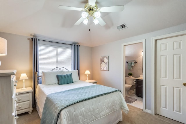 carpeted bedroom with vaulted ceiling, ceiling fan, and ensuite bathroom