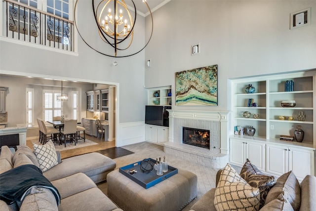 living room featuring an inviting chandelier and a brick fireplace